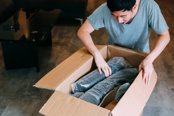 Zaskoczony Asian Man Unboxing pakiet w domu — Zdjęcie stockowe