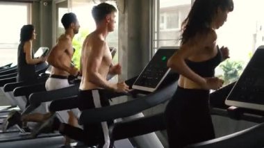 Modern spor salonunda koşu bandında egzersiz yapanlar. Fitness erkek ve kadın birlikte çalışma