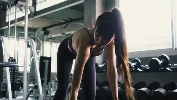 Fitness-Frau macht gebückte Hantelrudergymnastik im Fitnessstudio — Stockvideo