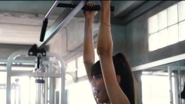 Güçlü kadın spor salonunda barlarda çene up egzersiz yapıyor