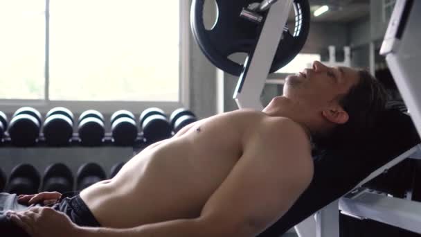 Cansado homem relaxante no banco depois de fazer exercício de imprensa no peito no ginásio — Vídeo de Stock