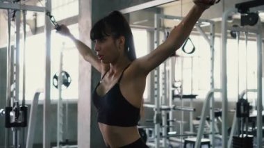 Fit genç kadın spor salonunda göğüs egzersiz üzerinde kablo çapraz yapıyor