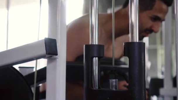Uomo che esercita i muscoli addominali con la macchina della stampa in palestra — Video Stock