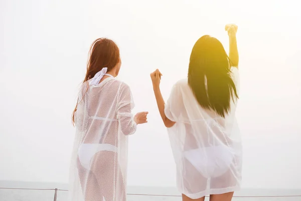 Women in bikini raising hands up on yacht in sea — Stock Photo, Image