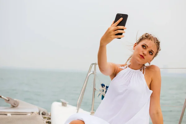 Attractive woman taking selfie on yacht in sea