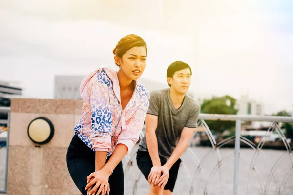 Asian athletes lunging on bridge — Stock Photo, Image