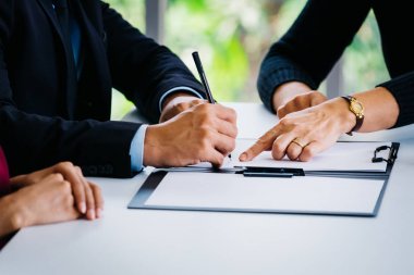 Sözleşmede imza için adam yeri gösteren iş kadını