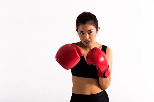 Portrait of a young female boxer punching on white isolated background with copy space