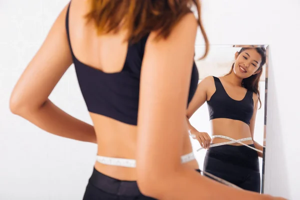 젊은 아시아 여자 측정 허리 와 테이프 에 a 거울 — 스톡 사진