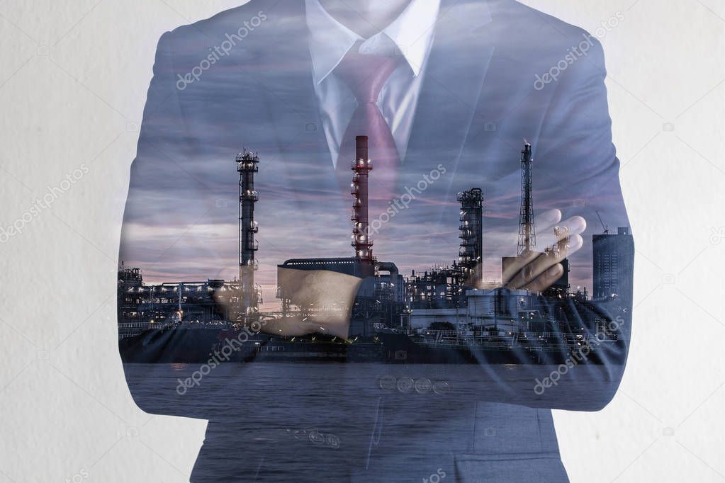 Double exposure image of Business man with petroleum oil refinery plant beside river