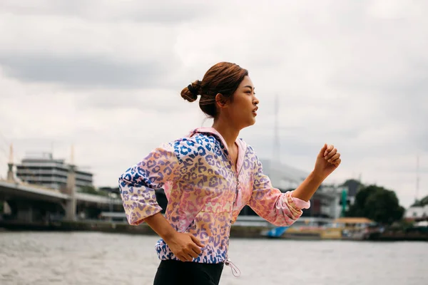 川沿いを走るアジア人女性 — ストック写真