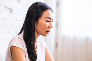 Evde Üzgün düşünceli Asyalı kadın