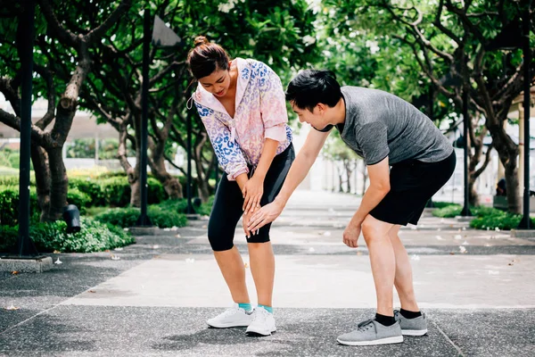 Mężczyzna pomaga kobiecie z kontuzjowanym kolanem — Zdjęcie stockowe