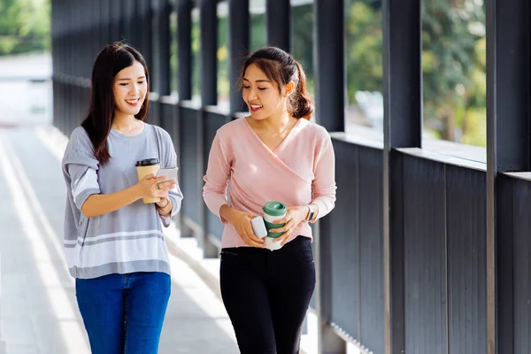 Jóvenes mujeres de negocios asiáticas hablando mientras caminan en el edificio de oficinas en ropa casual — Foto de Stock