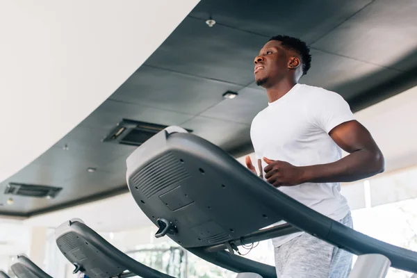 Sportsman working out on training machine — Stock Photo, Image