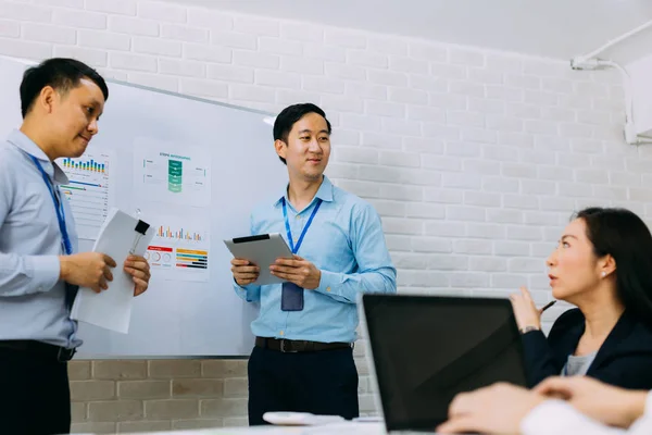 Giovani uomini d'affari asiatici che discutono nella sala riunioni dell'azienda — Foto Stock