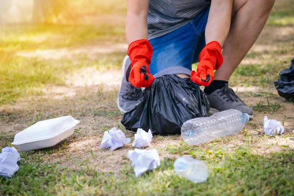 Jonge man het verzamelen van vuilnis in vuilniszak in het Park — Stockfoto