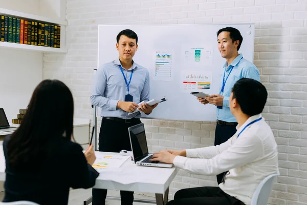 Jóvenes empresarios asiáticos discutiendo en la sala de reuniones de la empresa — Foto de Stock