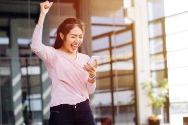 Asyalı kadın telefonla haber aldıktan sonra seviniyor