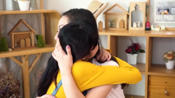 Sonriente hija asiática abrazando a su madre en la sala de estar en casa — Vídeo de stock