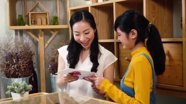 Sorridente asiatica madre e figlia con carta — Video Stock