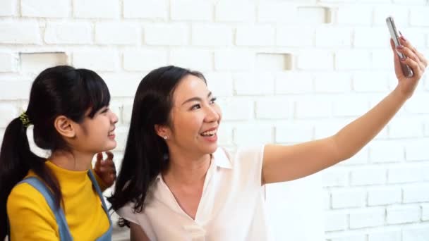 Feliz Asiática adolescente hija y de mediana edad madre tomando selfie o video llamadas — Vídeo de stock