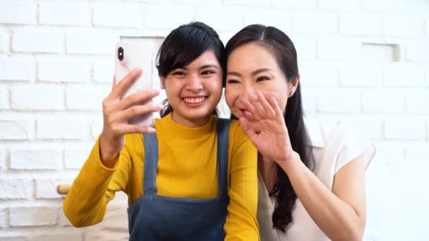 Felice asiatico adolescente figlia e madre di mezza età prendendo selfie o videochiamata — Video Stock