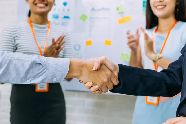 Young Asian business man and business woman giving a handshake gesture and cheering business workers — Stock Photo, Image