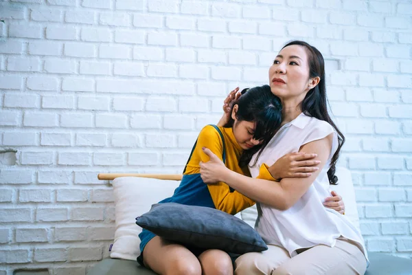 Asian mother comforting crying teenage daughter in miserable, stressed, depressed, sad state of mind — Stock Photo, Image