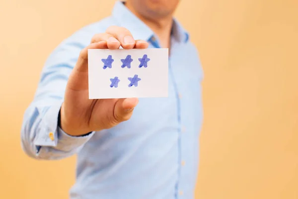 Zakenman toont vijf gele sterrenkaart in felle kleur achtergrond — Stockfoto