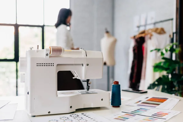 Sewing machine and papers on desk in workshop — Stock Photo, Image