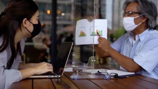 Aziatisch zakenman en vrouw bespreken in coffeeshop met maskers op — Stockvideo