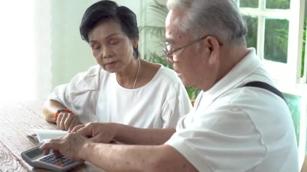 Asiática senior pareja estresado y serio contando con calculadora y tener dinero problema — Vídeo de stock