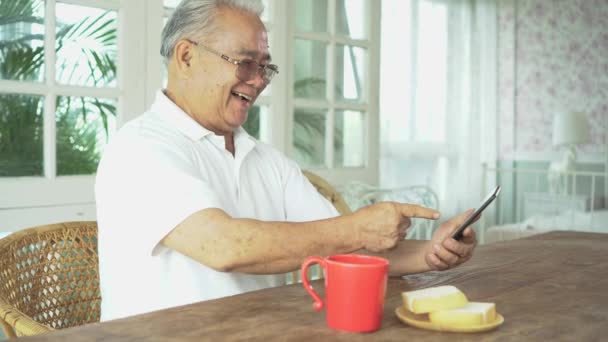 Senior asiatico uomo utilizzando smartphone durante la prima colazione — Video Stock