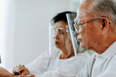 Yüz kalkanları olan yaşlı bir etnik çift.