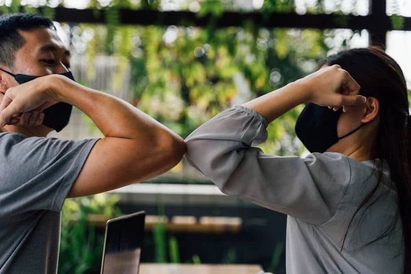 Mujer asiática y amigos hombres que usan mascarilla al aire libre. Amigos saludando y temblando con los codos como nuevo normal. Corona Virus - Covid 19 codo golpes estilo de saludo para evitar el contacto y la propagación del virus — Foto de Stock