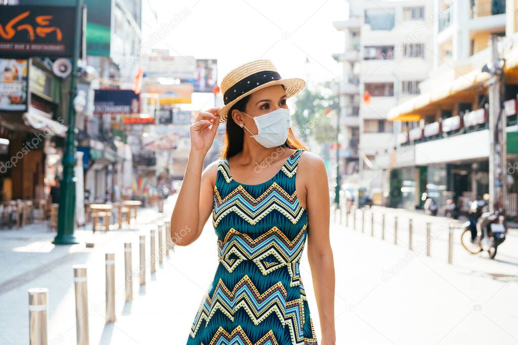 20s Hispanic Brunette woman in a protective mask wear summer sleeveless summ dress in Asia.