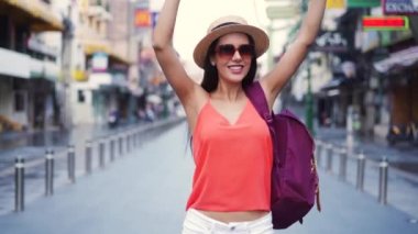 Genç esmer kadın tatilde sırt çantalı şapka takıyor.