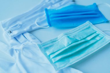 Mavi arka planda tıbbi koruyucu maskeler ve kopyalama alanı. Coronavirus Covid-19 salgınına karşı korunmak için tek kullanımlık yüz maskeleri. Sağlık hizmeti tıbbi cerrahi konsepti