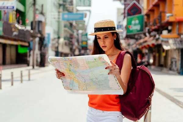 Młoda Latynoska brunetka patrzy na mapę na wakacje — Zdjęcie stockowe