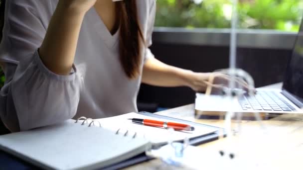 Asian beautiful woman wearing a protective face shield with partition using computer in restaurant. — Stock Video