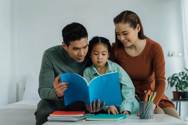 Asiático padre y madre lectura libro con hija —  Fotos de Stock