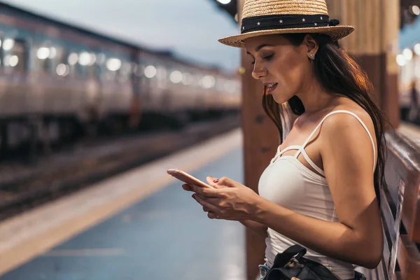 Young Hispanic Brunette woman using phone on train platform — Stock Photo, Image