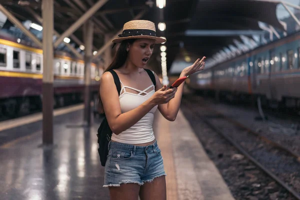 Joven mujer mexicana sosteniendo teléfono en plataforma de tren —  Fotos de Stock