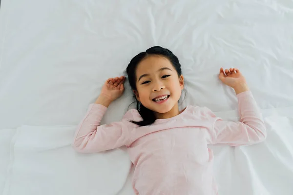 Портрет молодої азіатки, що лежить на спині, посміхається — стокове фото