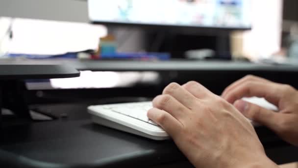 Hand des Mannes tippt auf PC-Tastatur über verschwommenem Hintergrund — Stockvideo