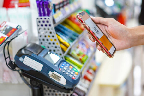 Hand of man making a contactless payment using a smartphone.