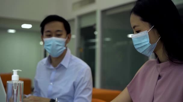 Dois colegas de trabalho sentados à mesa usando revestimentos protetores de máscara facial Covid-19, novo normal, proteção, saúde, segurança — Vídeo de Stock
