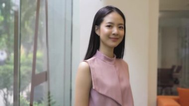 Ofis binasında kollarını kavuşturmuş genç Asyalı iş kadını. Çinli Koreli Asya 'lı akıllı kadın kollarını kavuşturmuş portre videosu çekiyor.