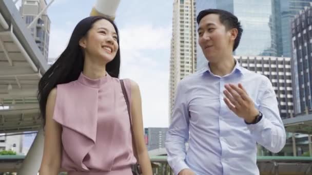 아시아의 젊은 사업가들은 사무실 건물 근처를 걷다가 이야기를 나눈다. 매력적 인 아시아 사업가이자 남자 의대화 - 4K 고품질의 걷기 — 비디오